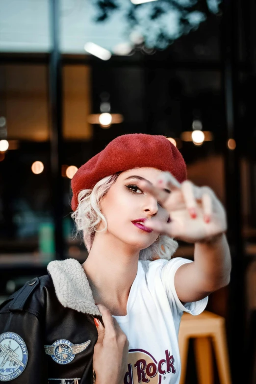 a woman in a red hat standing near some wooden posts