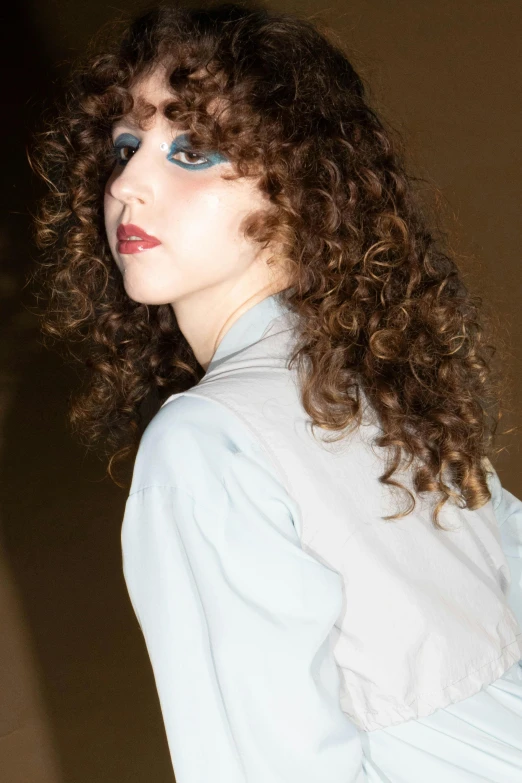 a model wearing blue makeup with long wavy hair