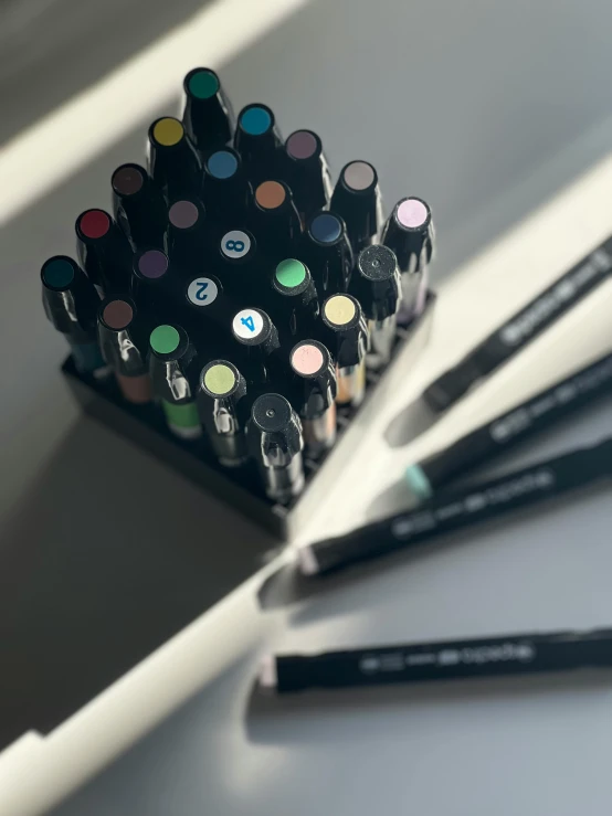 an assortment of marker pens and markers resting on a desk