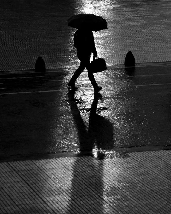 a man walks along a beach with his umbrella over him