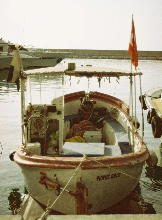 small boat tied up to dock near another small boat