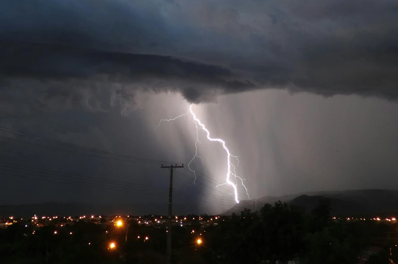 two lightnings shine behind dark storm clouds
