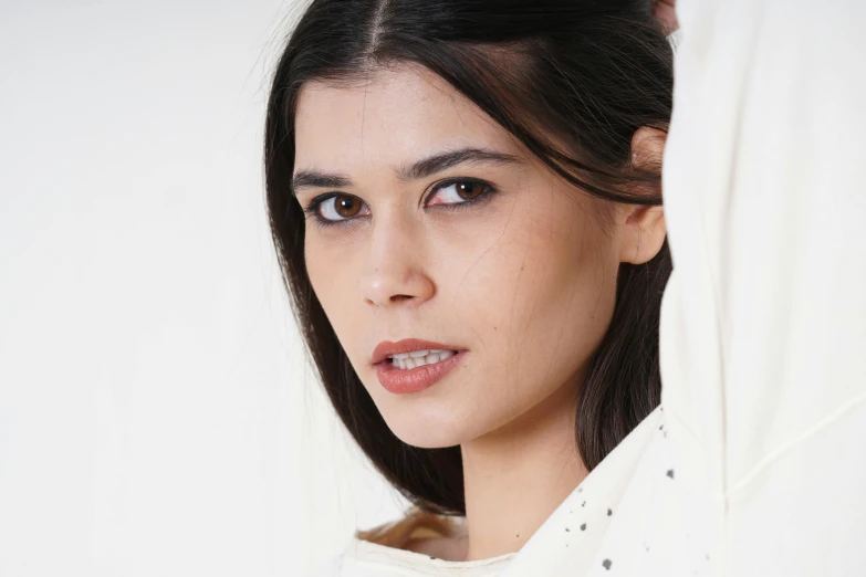 a woman with brown hair and a white shirt