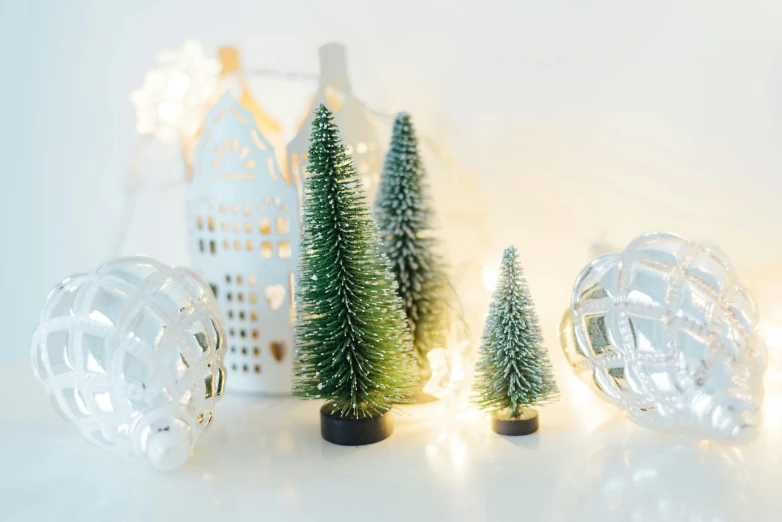 a few miniature christmas trees are inside of a glass container