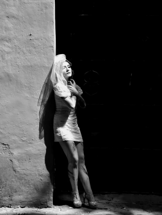 a woman is standing against a wall and talking on her cell phone