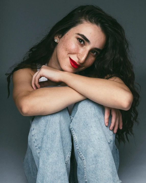 a woman in a white shirt and jeans posing for the camera