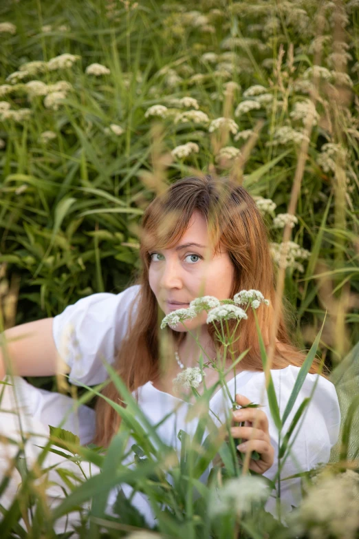 a beautiful young woman sitting in a field