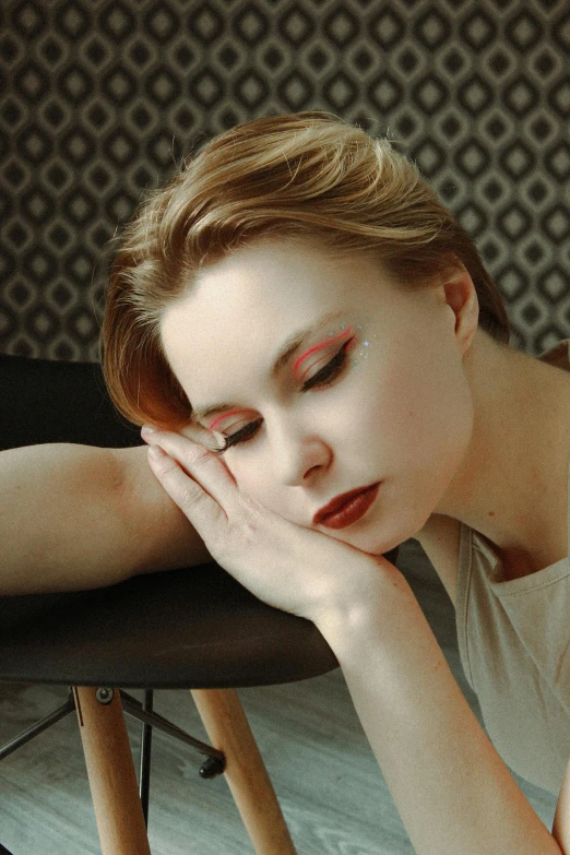 a woman sitting in a chair looking down