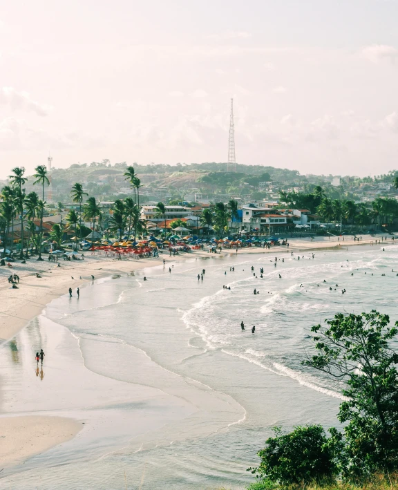 many people in the water near a sandy beach