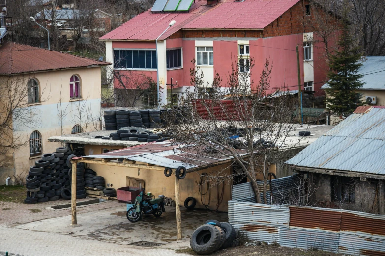 an old shack next to a road and several buildings