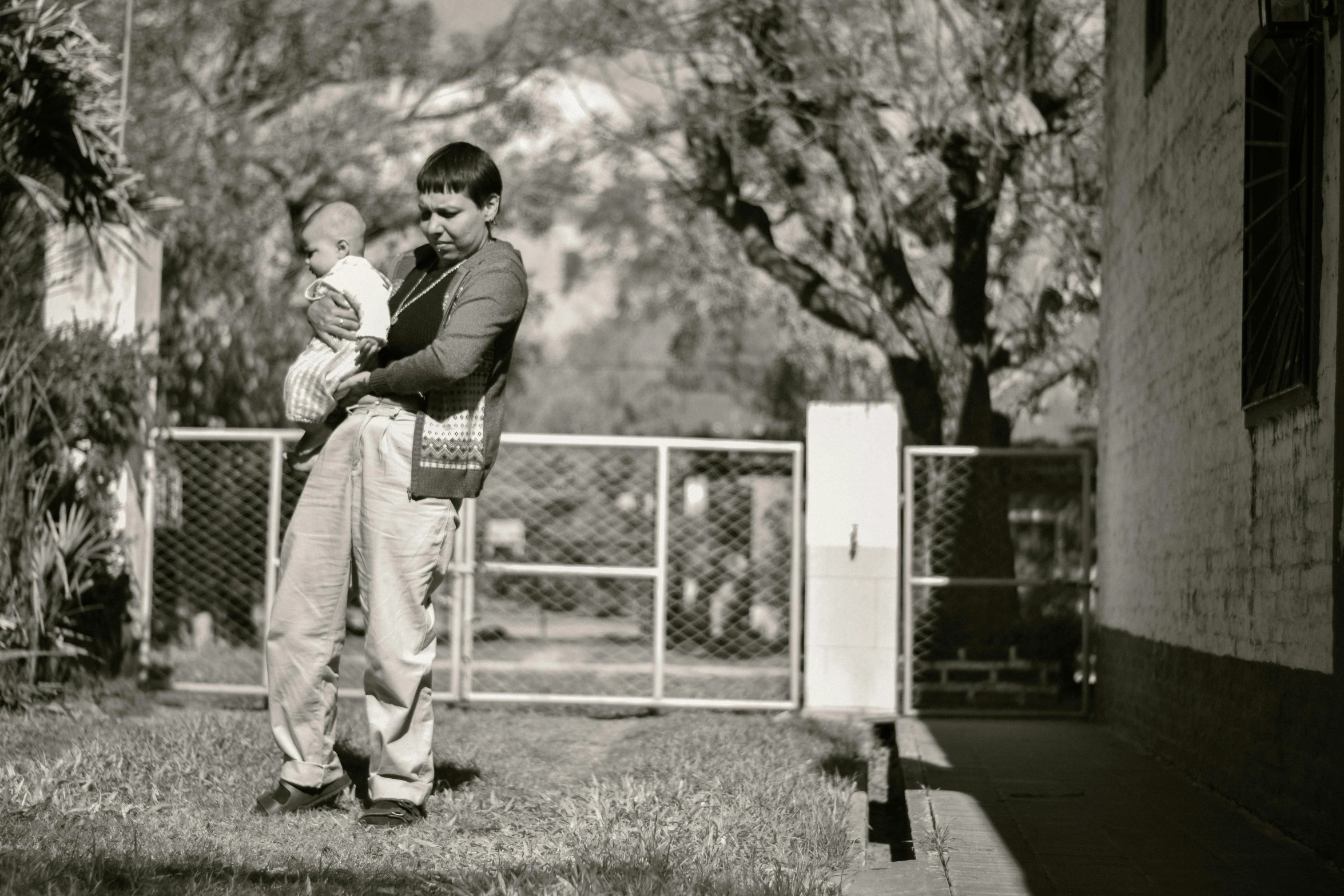 a man with a baby in his arms in the yard