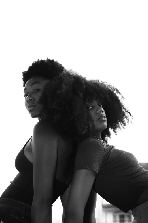 two young ladies, both in black and white, pose for a pograph