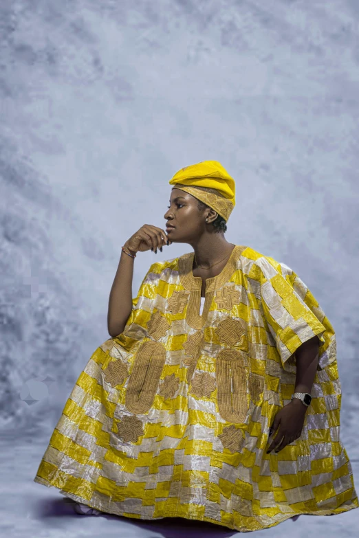 woman in yellow and white patterned dress sitting down