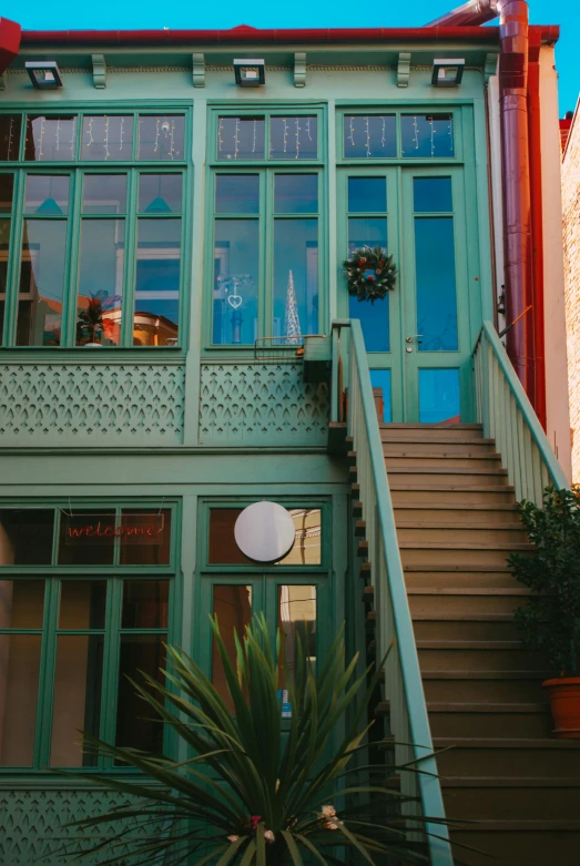 green building with a large clock on the front of it