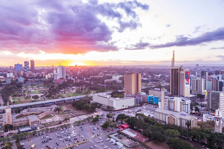 the sun rises over a large city with tall buildings