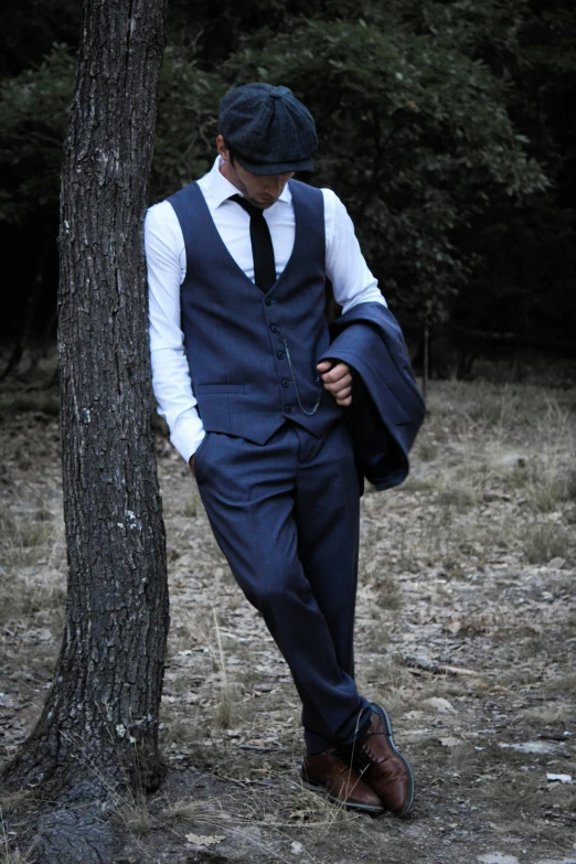 man leaning on a tree trunk in a forest