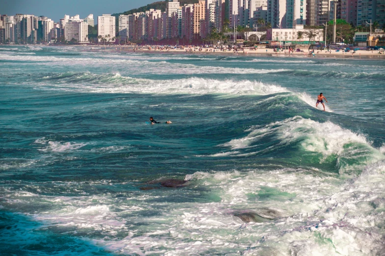 a couple of people riding a wave on top of surfboards