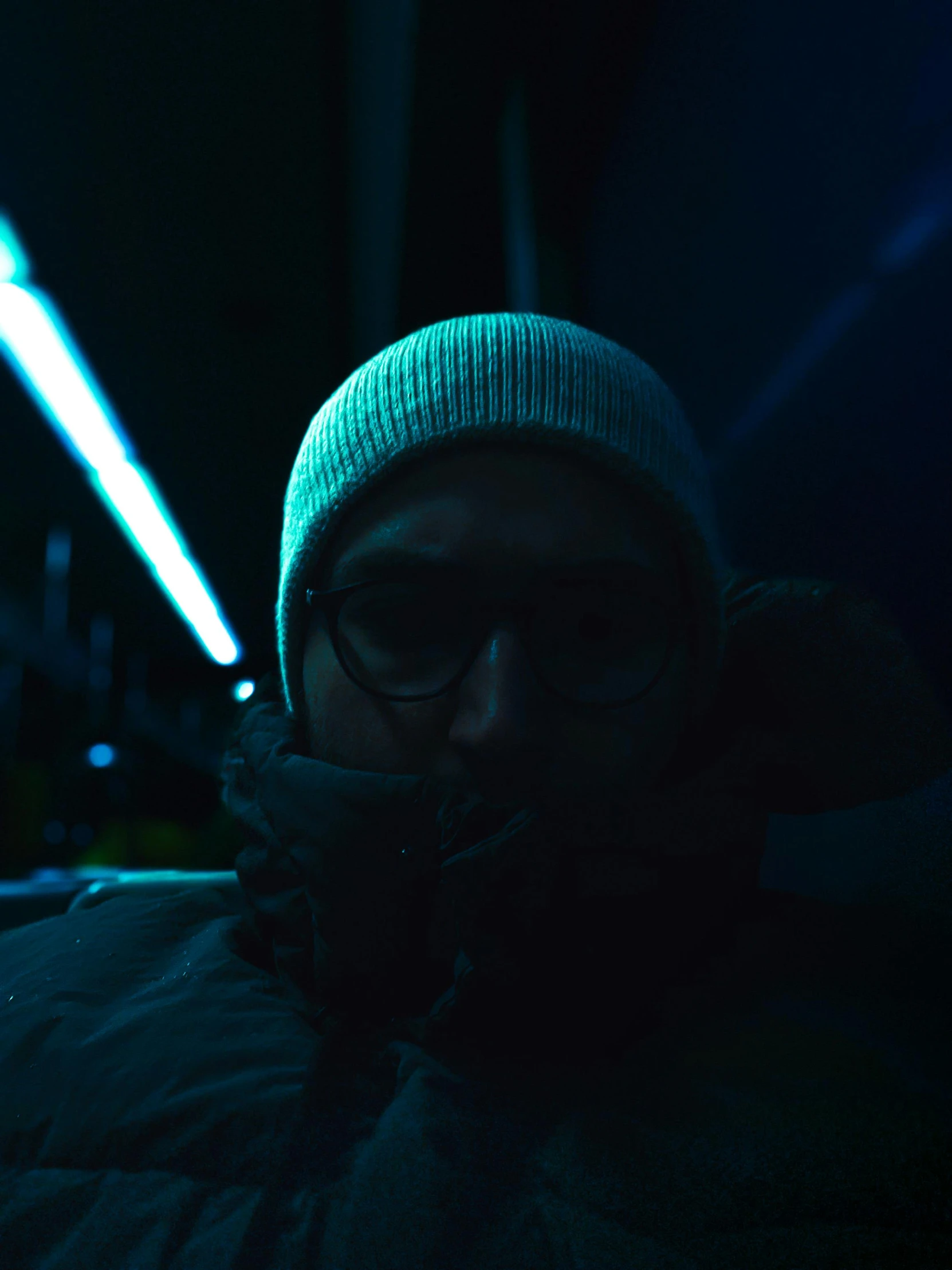 a man wearing a winter coat standing outside at night in the dark