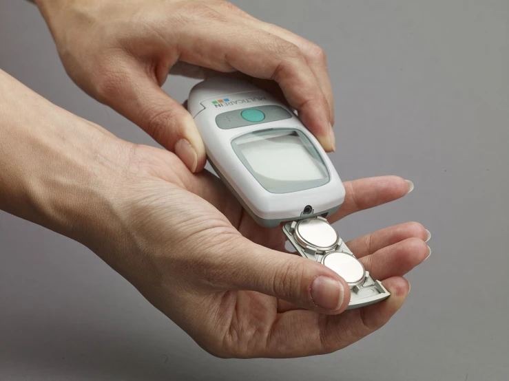 a close up of a person holding a cell phone, medical equipment, high res photo, -step 50, spoon placed