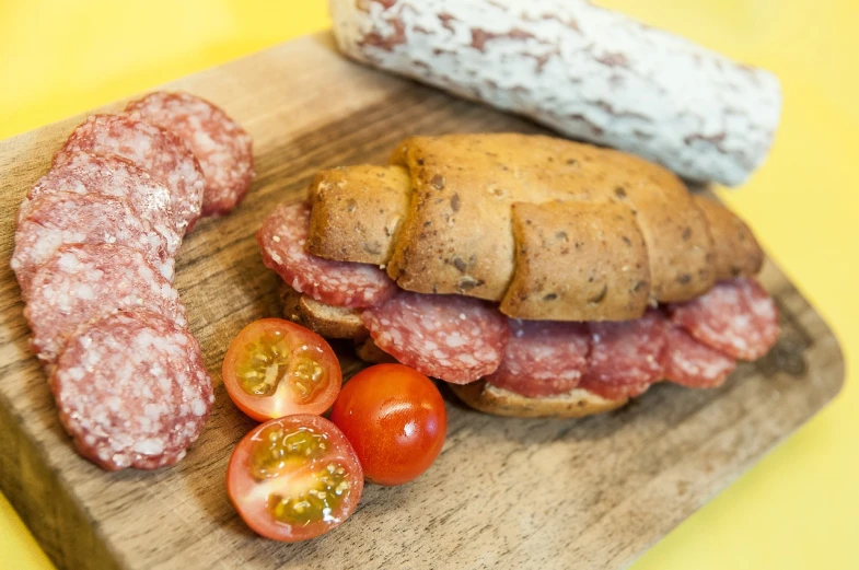 a sandwich sitting on top of a wooden cutting board, by Dietmar Damerau, cheese and salami on the table, sausages, high quality photos, close-up product photo