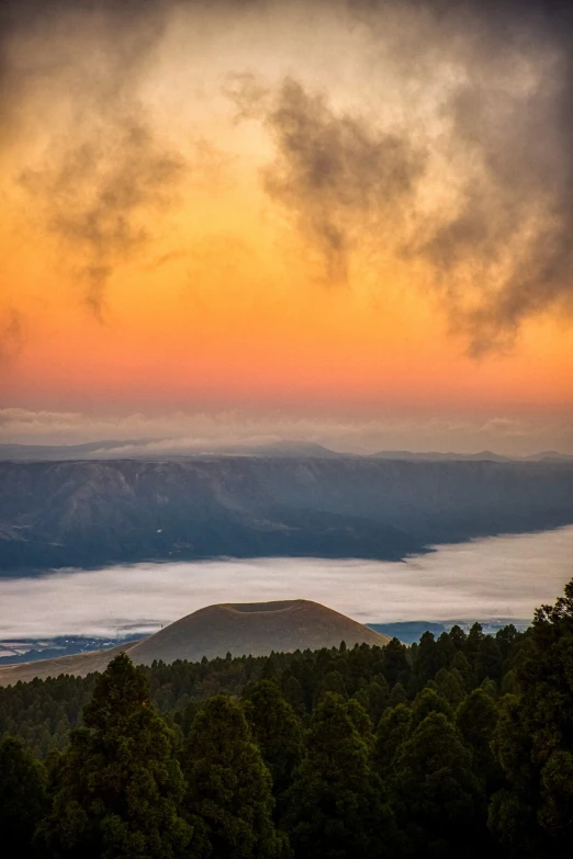 a couple of cows standing on top of a lush green hillside, a picture, by Jeffrey Smith, beautiful new mexico sunset, looking down at a massive crater, above low layered clouds, post-processed