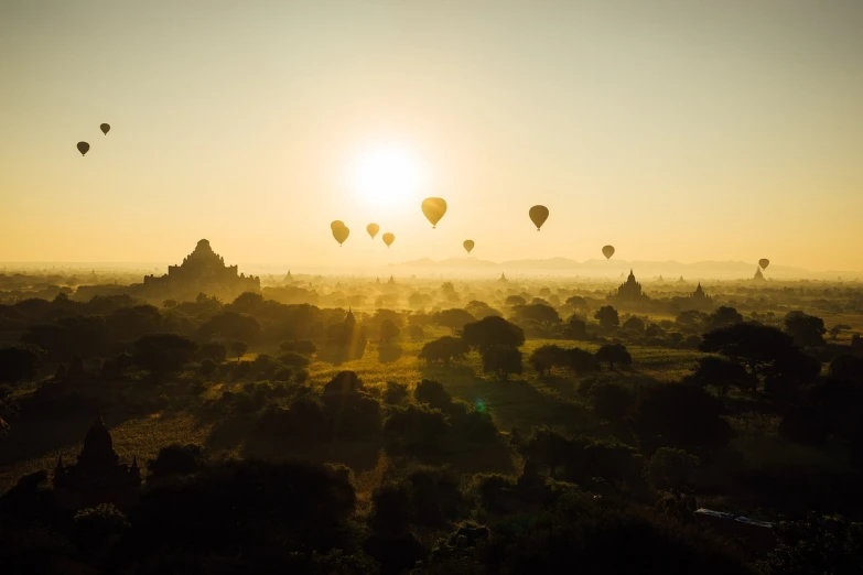 a group of hot air balloons flying in the sky, unsplash contest winner, romanticism, myanmar, sun and shadow over a city, ancient”, by emmanuel lubezki