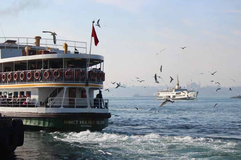 a large boat floating on top of a body of water, by Fikret Muallâ Saygı, pexels, hurufiyya, bird flocks!!, bus, sunday afternoon, avalon