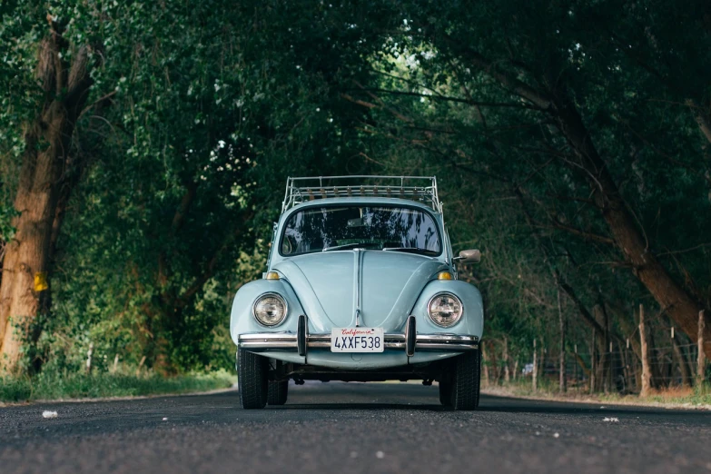 a blue vw beetle parked on the side of a road, a picture, unsplash, tamborine, high quality film still, seafoam green, zac retz