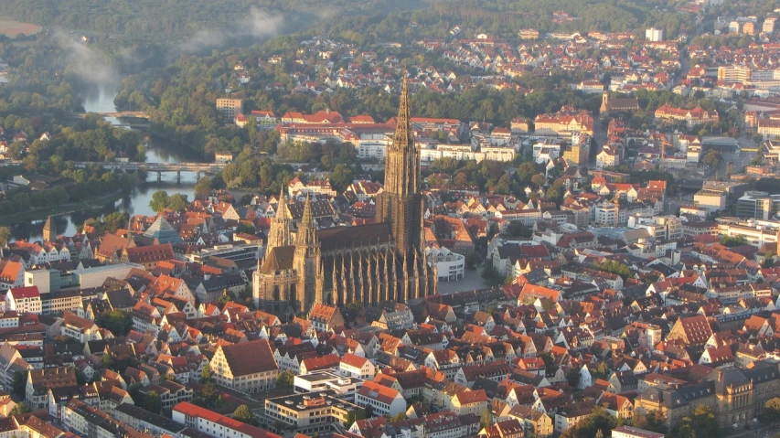 a view of a city from a bird's eye view, by Juergen von Huendeberg, cathedral of sun, brown, in the early morning, wikipedia