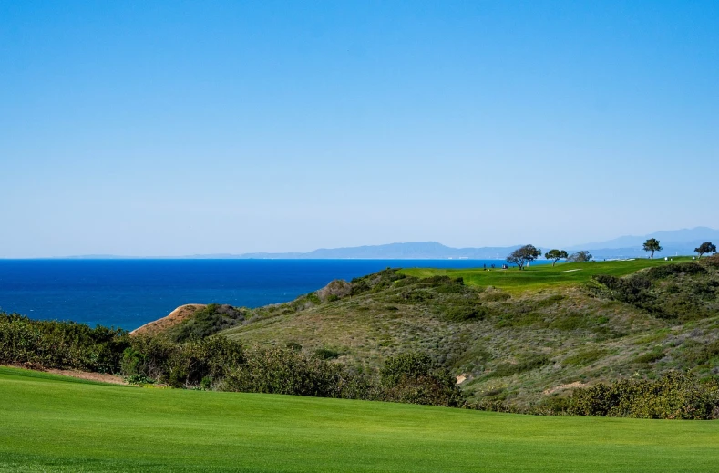 a golf course with a view of the ocean, by Arnie Swekel, tones of blue and green, ocean cliff view, high res, oc