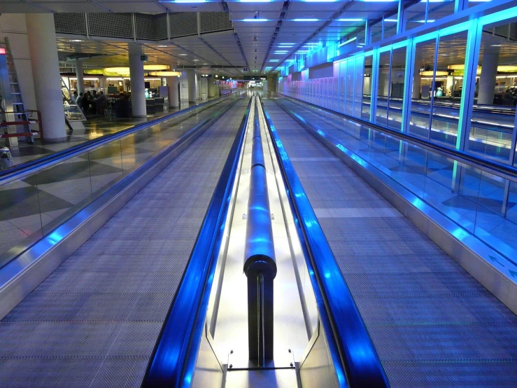 an escalator in an airport with blue lights, by Kurt Roesch, flickr, bowling alley carpet, long view, walkways, gateway to futurisma