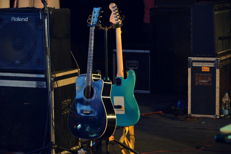 a group of guitars sitting on top of a stage, a picture, by Dicky Doyle, shutterstock, blue body, stock photo