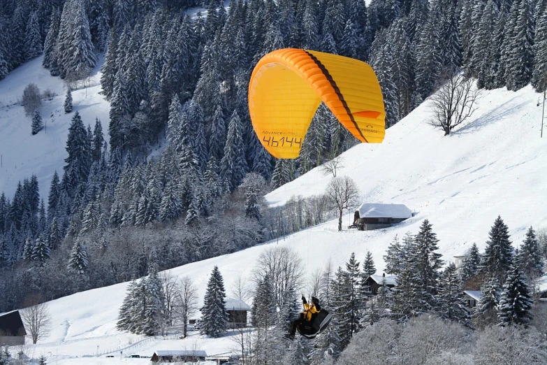 a person flying a kite on top of a snow covered slope, a picture, by Karl Stauffer-Bern, shutterstock, figuration libre, gondola, yellow, black forest, breitling