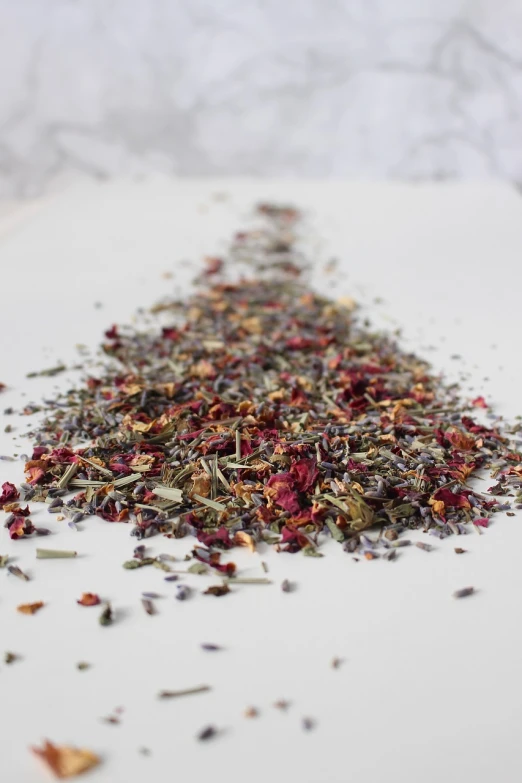 a pile of dried herbs sitting on top of a table, a picture, inspired by Annie Rose Laing, tumblr, close-up product photo, on a gray background, tea, red and purple palette