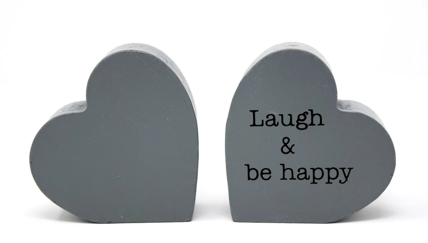 a pair of wooden hearts that say laugh and be happy, inspired by Hugh Hughes, slate, productphoto, figurines, tombstone