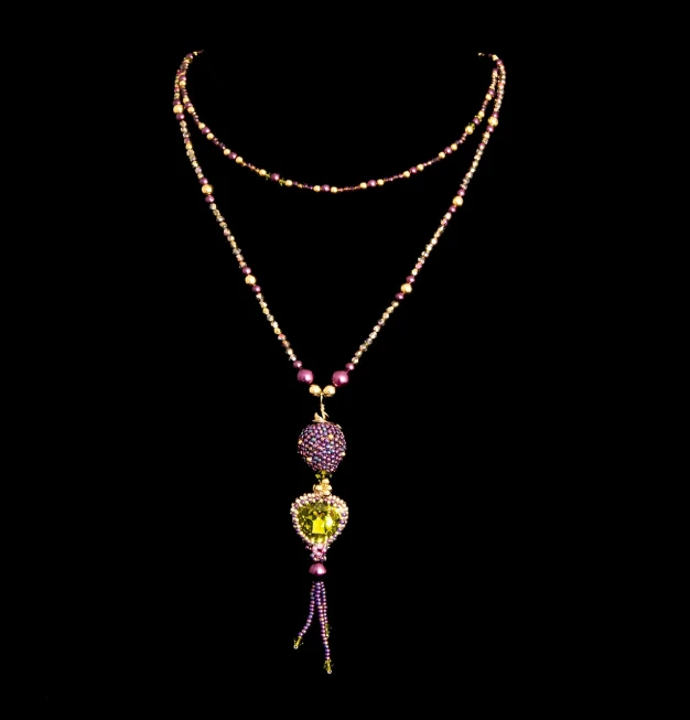 a close up of a necklace on a black background, a digital rendering, renaissance, dressing tassels gemstones, lime and violet, very beautiful photo, snapchat photo