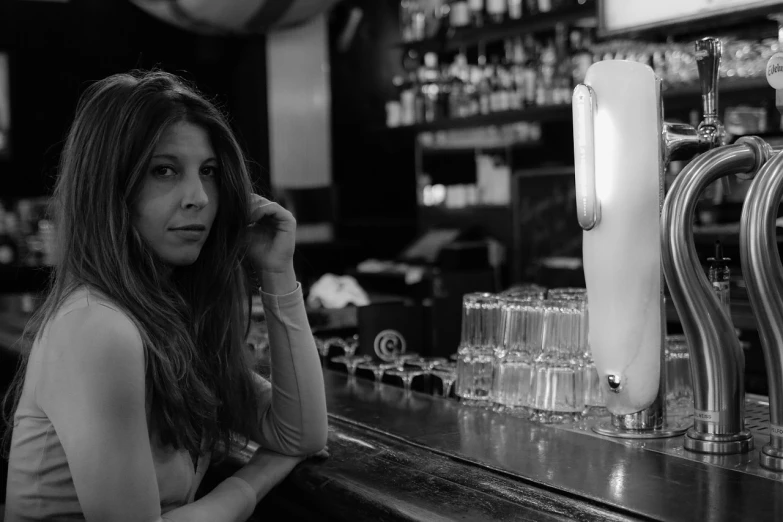 a woman sitting at a bar talking on a cell phone, a black and white photo, inspired by Larry Fink, tumblr, art nouveau, angela sarafyan, portrait shot 8 k, bartending, sofia coppola