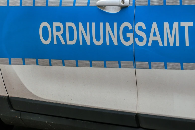 a blue and white car with the word ordningsamt written on it, a stock photo, by Oskar Lüthy, shutterstock, police officers, hannover, detail shot, panorama