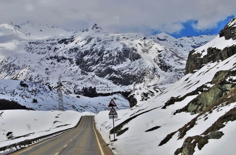 a road with snow covered mountains in the background, a photo, by Werner Andermatt, flickr, les nabis, the tunnel into winter, marker”, heaven in the top, impressive detail : 7