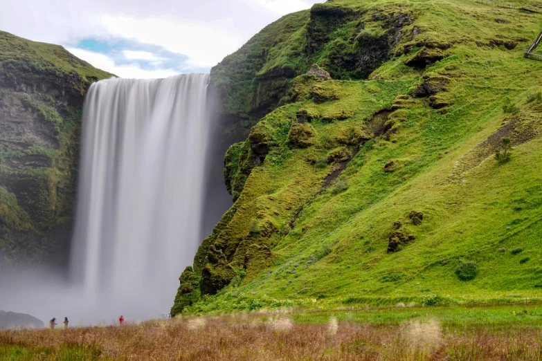 a group of people standing in front of a waterfall, by Muggur, pexels contest winner, hurufiyya, seen from a distance, hyperrealistic 8k uhd, wallpaper - 1 0 2 4, icelandic landscape