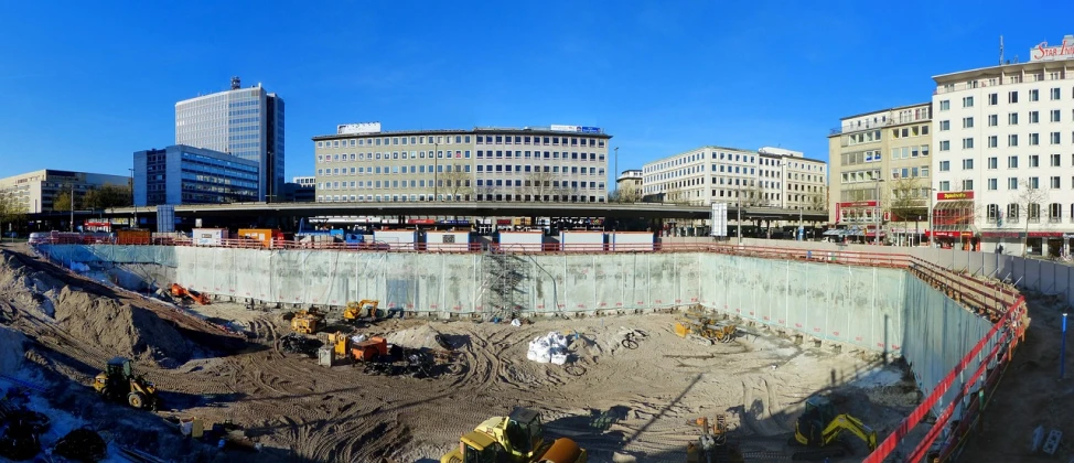 a construction site in the middle of a city, a photo, by Mathias Kollros, flickr, cinemascope panorama, underground, munich, blue sky
