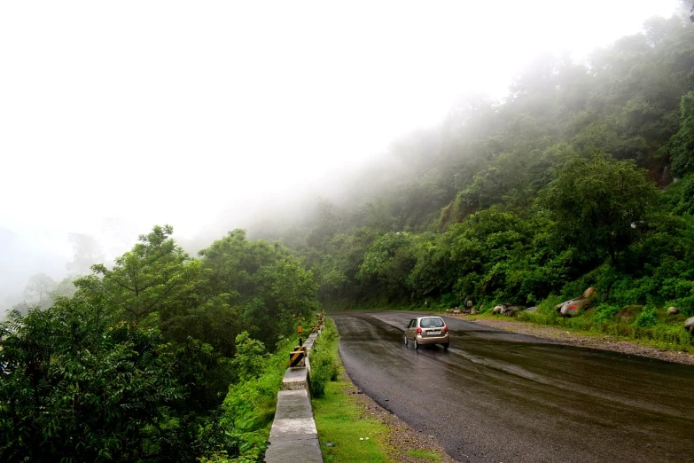 a car that is sitting on the side of a road, by Sudip Roy, flickr, samikshavad, thunder in the foggy jungle, mountain pass, indore, lush and green