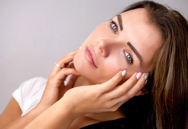 a beautiful young woman holding her hand to her face, a picture, shutterstock, closeup shot, smooth healthy skin, relaxed eyebrows, portrait shot 8 k