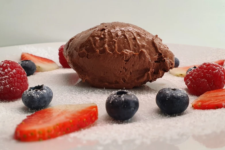 a chocolate ice cream ball surrounded by strawberries and blueberries, inspired by Joris van der Haagen, photograph taken in 2 0 2 0, 3/4 profile, chocolate frosting, alphonse muca