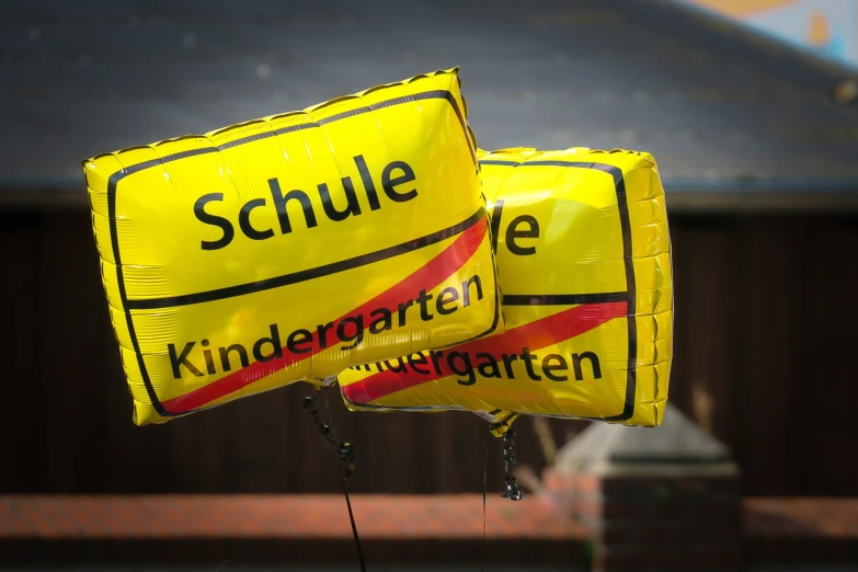 a bunch of balloons that are in the air, a picture, heidelberg school, sign, closeup photo, kindchenschema, yellow school bus