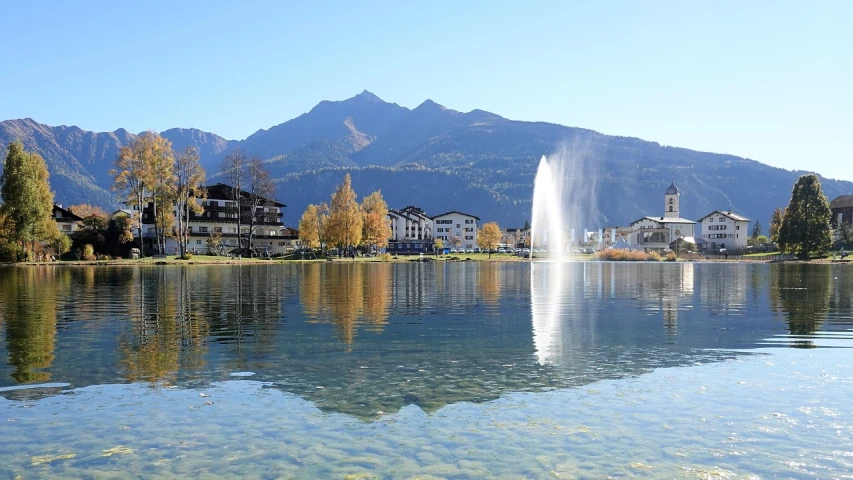 a large body of water with a fountain in the middle of it, by Werner Andermatt, pixabay, in the foreground a small town, october, afp, wikimedia