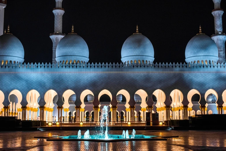 a large building with a fountain in front of it, by Sheikh Hamdullah, pexels contest winner, arabesque, holy lights, white sweeping arches, at midnight, black domes and spires