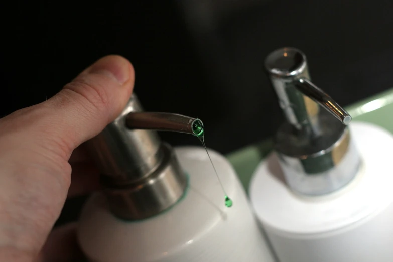 a close up of a person's hand near a soap dispenser, an airbrush painting, by Ben Zoeller, flickr, green pupills, surgical equipment, glowing threads of drop, clean thick line