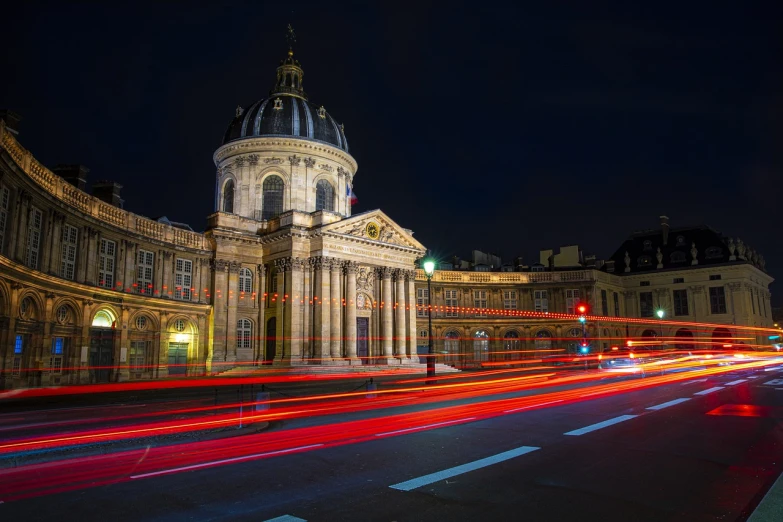 a large building with a clock tower next to a street, by Robert Griffier, shutterstock, paris school, lightpainting motion blur, pantheon, museum quality photo, traffic with light trails