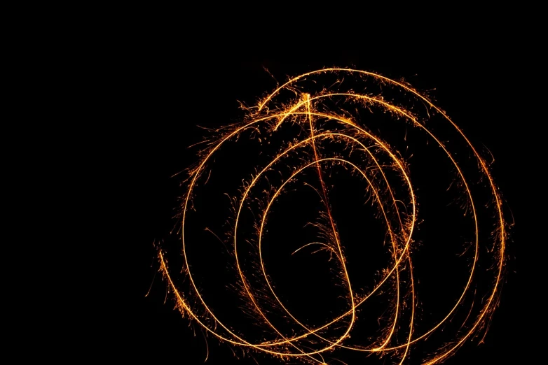 a close up of a sparkler on a black background, a microscopic photo, digital art, golden curve composition, long exposure photo, orange halo, high res photo